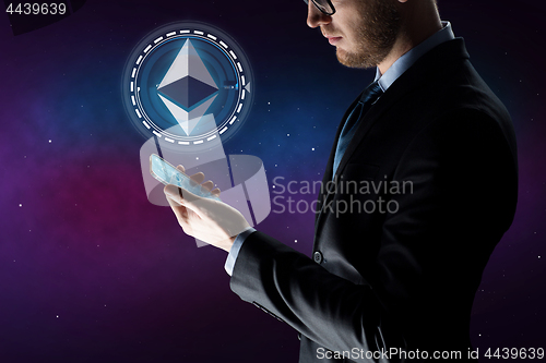 Image of businessman with smartphone and ethereum hologram