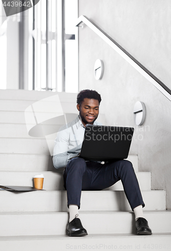 Image of african american businessman with laptop at office