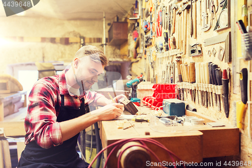 Image of carpenter working with wood plank at workshop