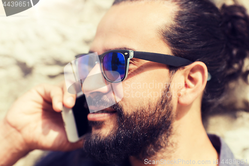 Image of man with smartphone calling on city street