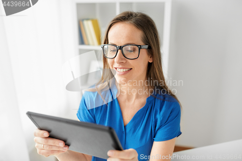 Image of woman with tablet pc working at home or office