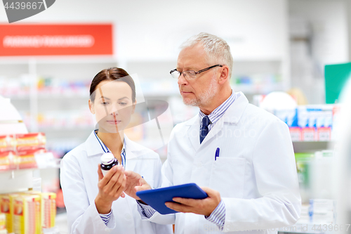 Image of apothecaries with tablet pc and drug at pharmacy