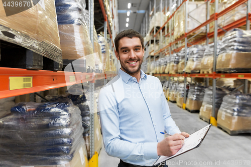 Image of businessman with clipboard at warehouse