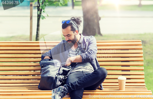 Image of man with backpack and earphones in city