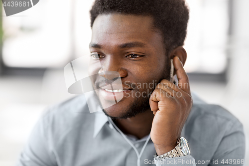 Image of close up of man with earphones listening to music