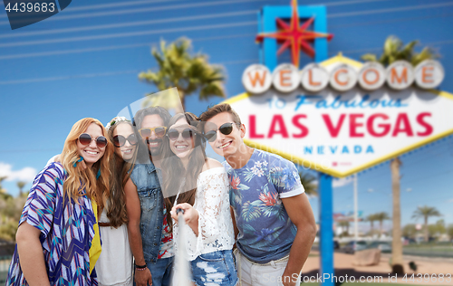 Image of friends taking selfie by monopod at las vegas sign