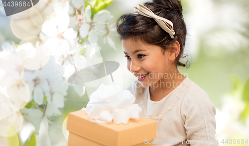 Image of happy girl with gift box over cherry blossom