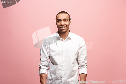 Image of The happy business man standing and smiling against pink background.