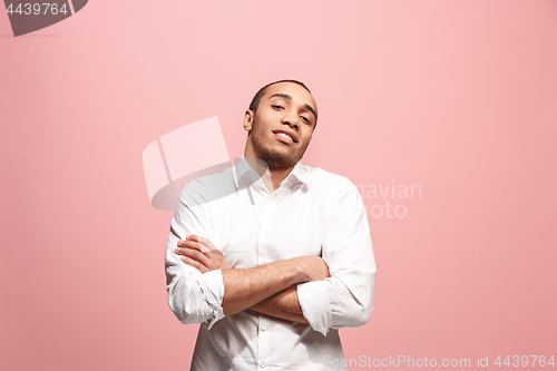 Image of The happy business man standing and smiling against pink background.