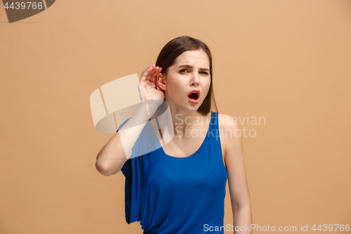 Image of The young woman is listening something on the pastel background.