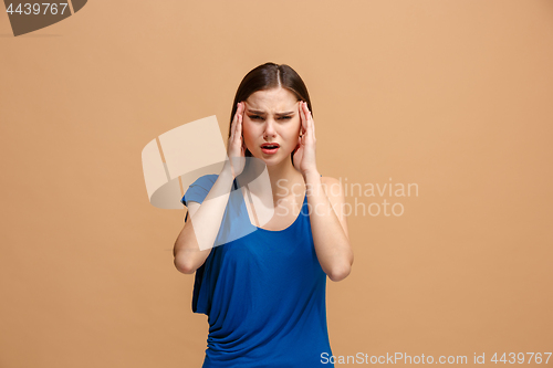 Image of Woman having headache. Isolated over pastel background.