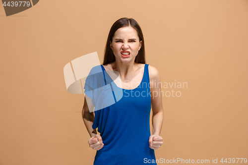 Image of Portrait of an angry woman looking at camera isolated on a pastel background