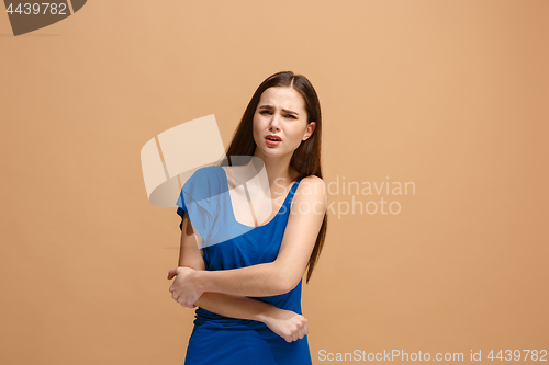 Image of The elbow ache. The sad woman with elbow ache or pain on a pastel studio background.