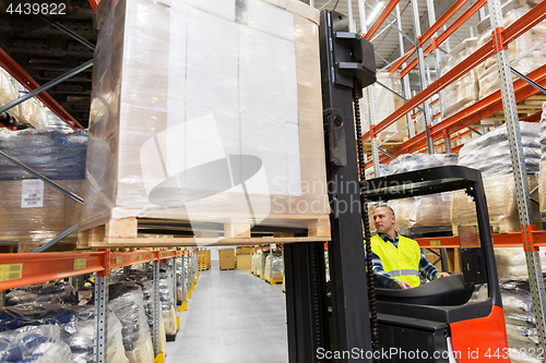 Image of loader operating forklift at warehouse