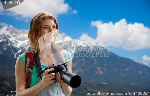 Image of woman with backpack and camera over alps mountains