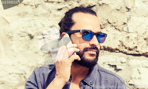 Image of man with smartphone calling on city street