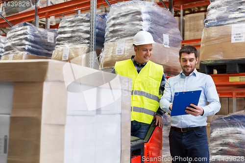 Image of businessman and loader in forklift at warehouse