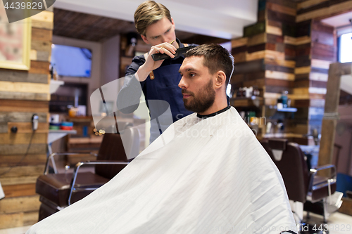 Image of man and barber cutting hair at barbershop