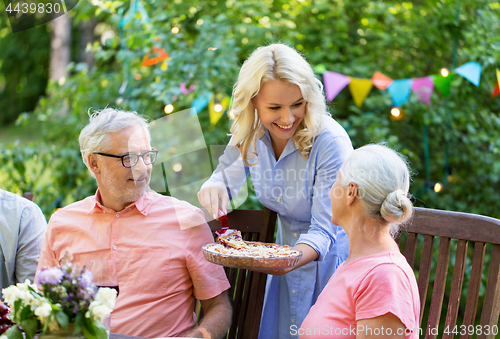 Image of happy family having dinner or summer garden party