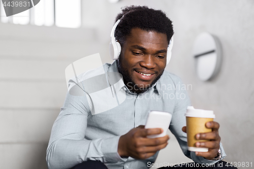 Image of businessman with headphones and smartphone