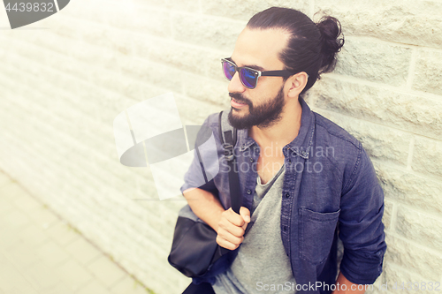 Image of man with backpack standing at city street wall