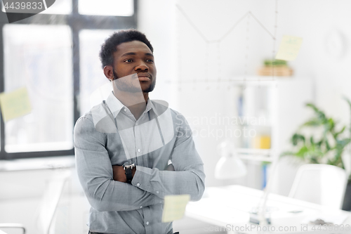 Image of businessman looking at glass board at office