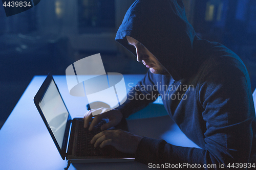 Image of hacker using laptop computer for cyber attack