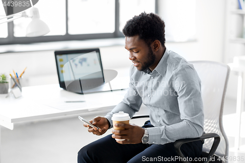 Image of businessman with smartphone and coffee at office