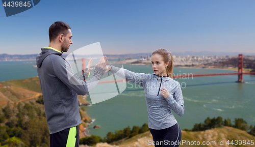 Image of happy woman with coach working on strike outdoors