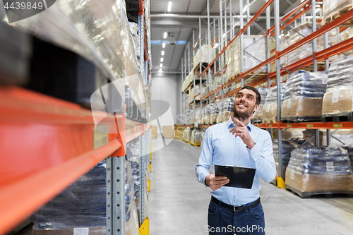 Image of happy businessman with clipboard at warehouse