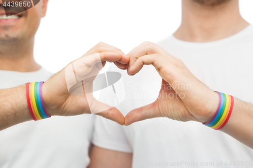 Image of gay couple with rainbow wristbands and hand heart