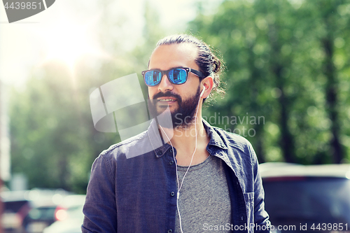 Image of man with earphones listening to music in city