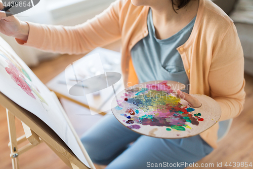 Image of artist with palette painting at art studio