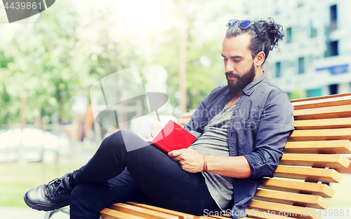 Image of man with notebook or diary writing on city street