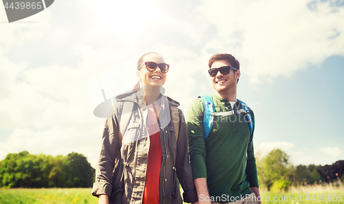 Image of happy couple with backpacks hiking outdoors