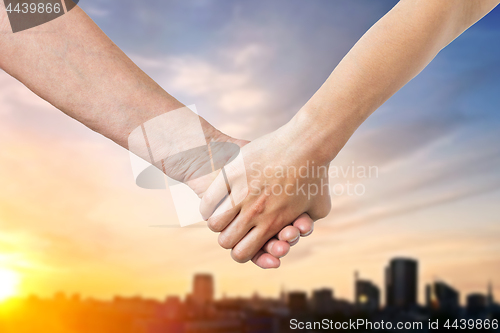 Image of close up of senior and young woman holding hands