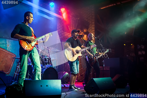 Image of Band performs on stage in a nightclub