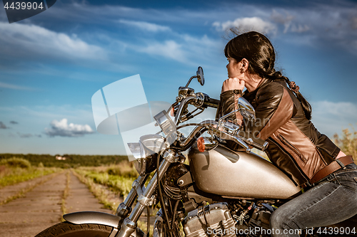 Image of Biker girl sitting on motorcycle