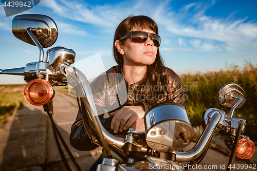 Image of Biker girl sitting on motorcycle