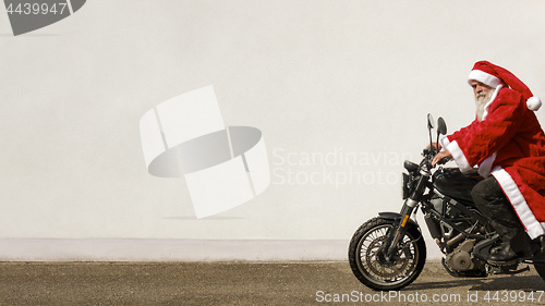 Image of man on a motorbike in a typical Santa Claus costume