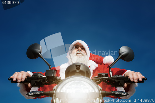 Image of man on a motorbike in a typical Santa Claus costume