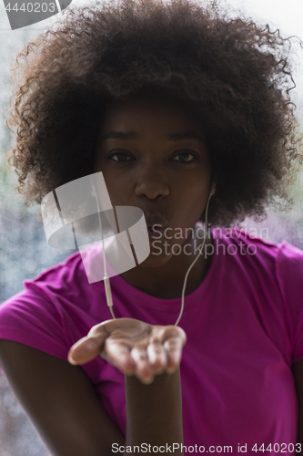 Image of portrait of young afro american woman in gym while listening mus