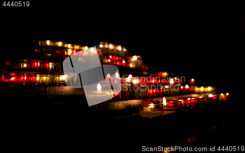 Image of Bright lights of burning candles in the darkness of the church