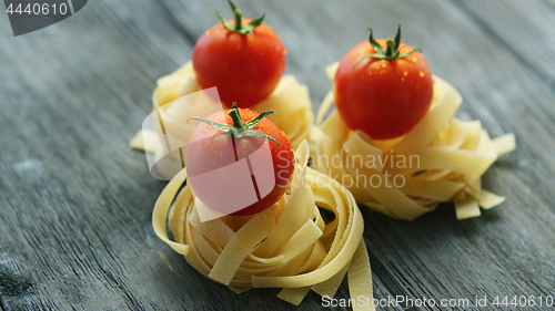 Image of Bunches of pasta with wet tomatoes