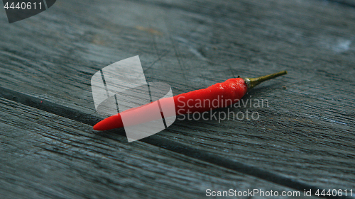 Image of Single red chili pepper on table
