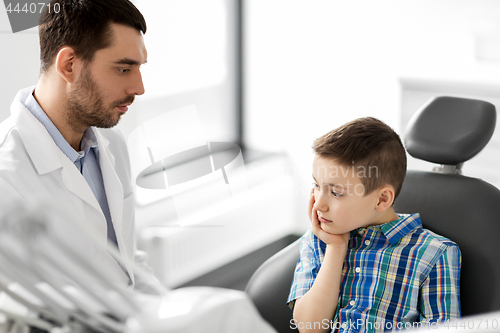 Image of dentist with patient having toothache at clinic