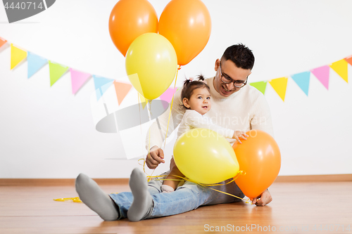 Image of father and daughter with birthday party balloons