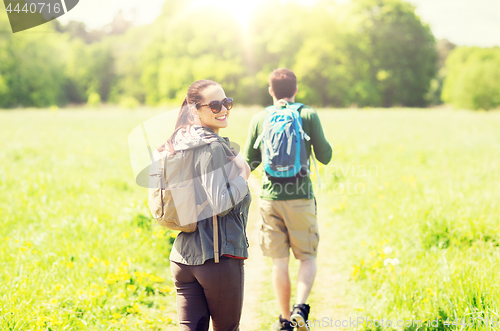 Image of happy couple with backpacks hiking outdoors