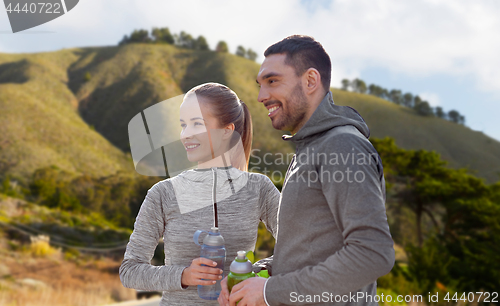 Image of couple of sportsmen with water over big sur hills