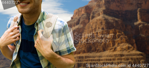 Image of close up of man with backpack over grand canyon